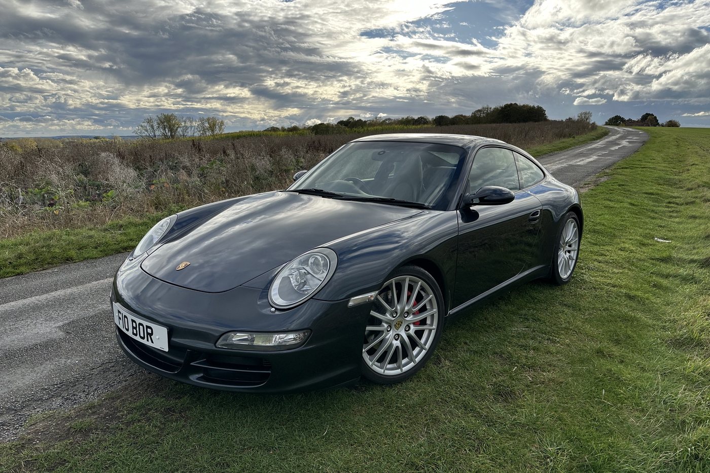 Grey Porsche 911 Carrera S of the 997 generation on a country lane