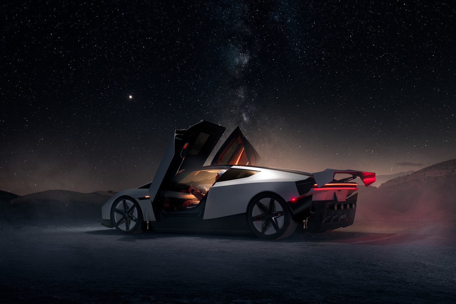 The new Tesla Roadster at night, doors up and rear wing deployed